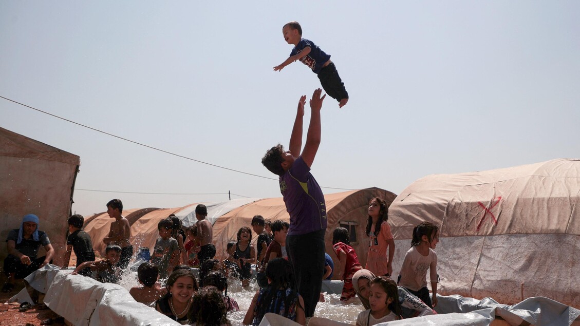 Una piscina in un campo per sfollati in Siria, in una zona controllata dai ribelli, 14 agosto 2023 © ANSA/AFP