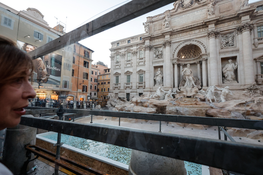 Fontana di Trevi senza acqua per il restauro, turisti lanciano monete in una vasca