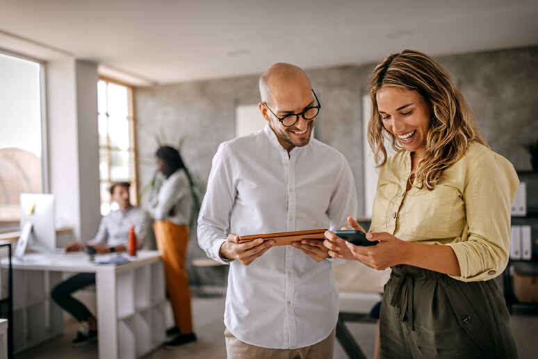 Due impiegati sorridenti foto iStock. - RIPRODUZIONE RISERVATA