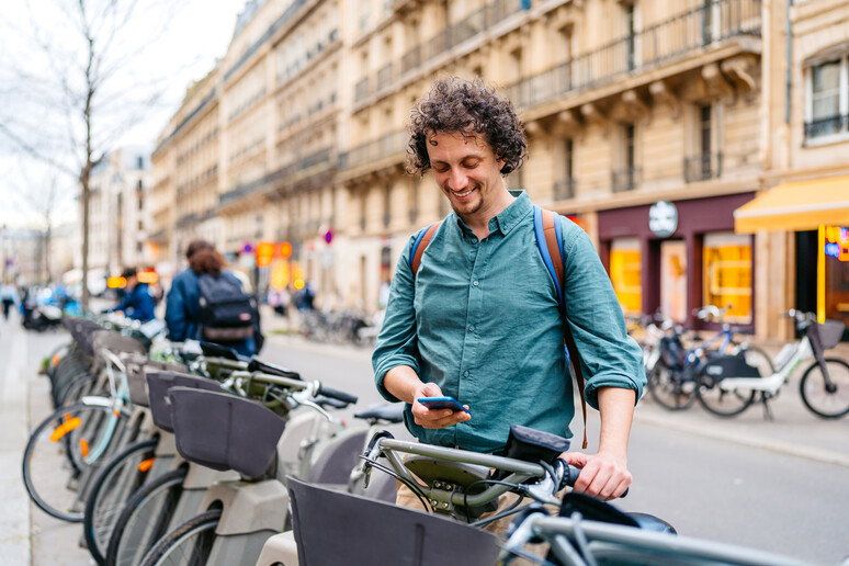 Un uomo noleggia una bicicletta elettrica in città foto iStock. - RIPRODUZIONE RISERVATA