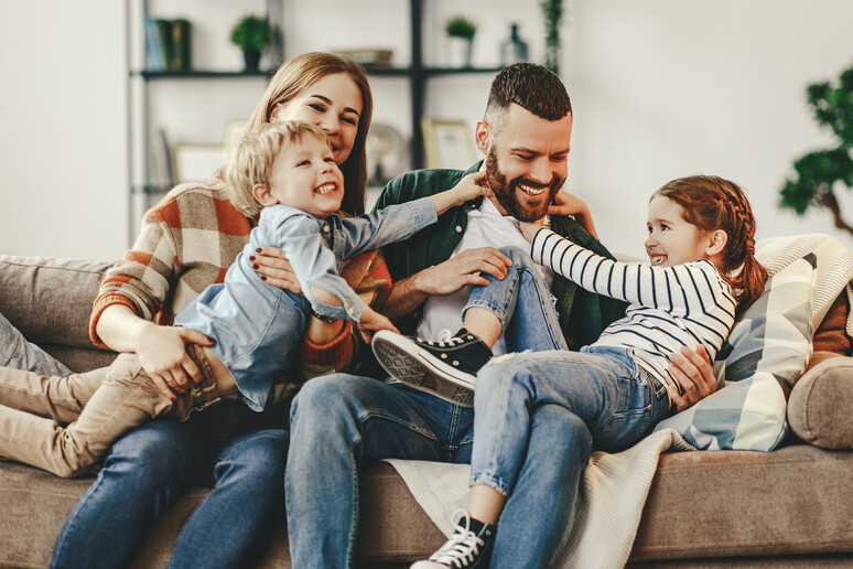 Una famiglia felice con genitori e due figli foto iStock. - RIPRODUZIONE RISERVATA