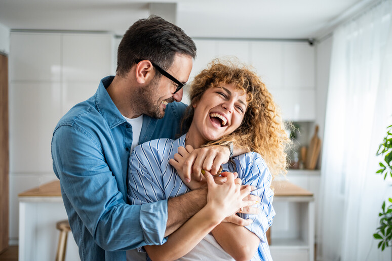 A wonderful scene of love and happiness between a couple in love enjoying their new apartment - RIPRODUZIONE RISERVATA